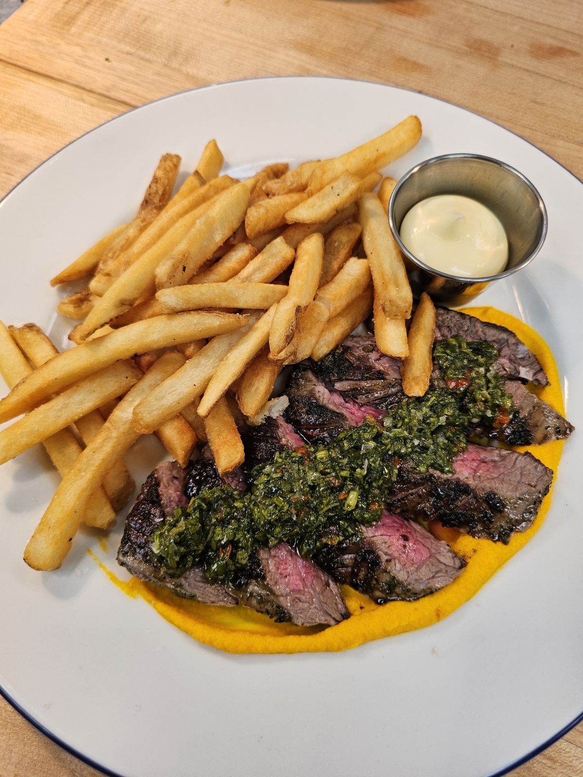 8oz flank steak with a fried egg on top, with chimichurri with a side of fries